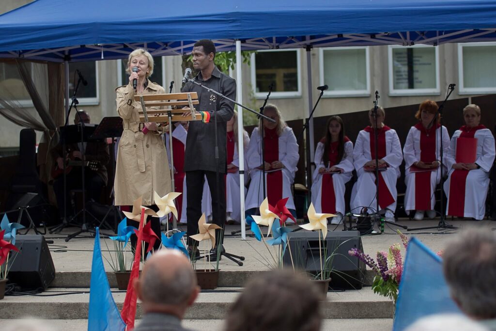 Daniel Osei Afrifa on stage with the choir behind him at the Holy Ghost Conference in Šiauliai, Lithuania